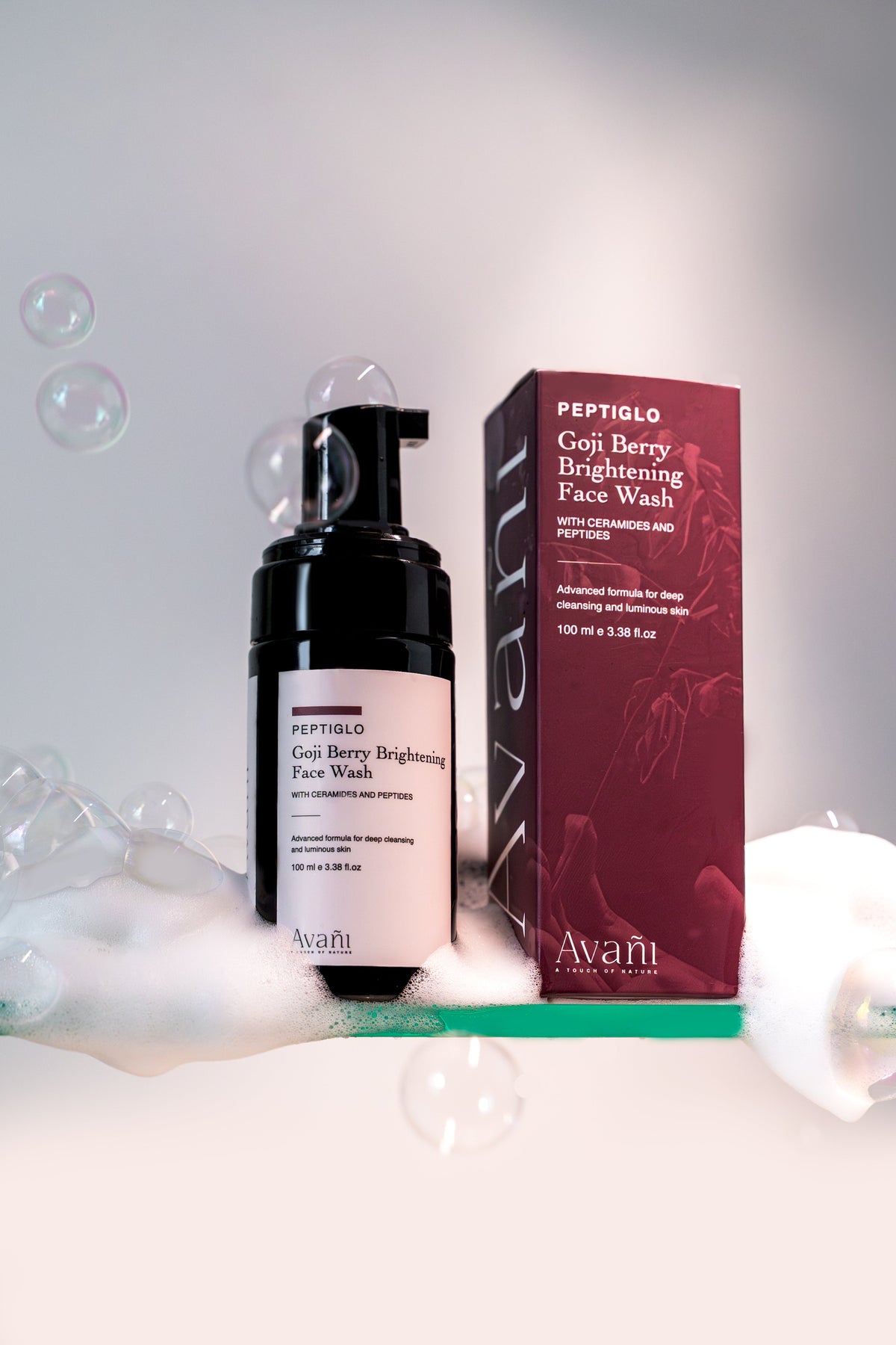 Avani Goji Berry Brightening Face Wash with packaging on a white background with bubbles.