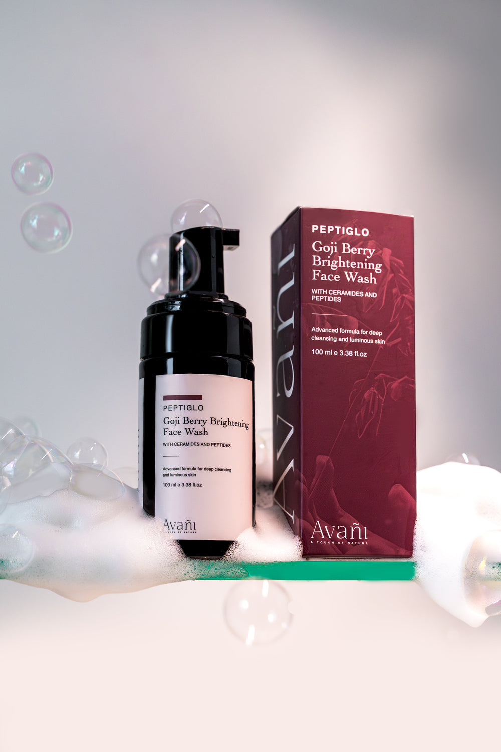 Avani Goji Berry Brightening Face Wash with packaging on a white background with bubbles.